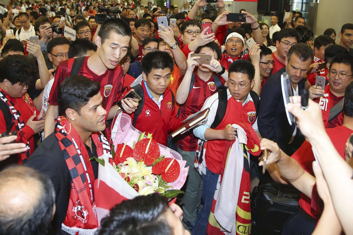 Brazilian soccer player Hulk, eft is surrounded by fans waiting at the airport in Shanghai Wednesday, June 29, 2016. Forward Hulk is expected to join Shanghai SIPG in a deal local media is predicting could be a record for the Chinese Super League. (Color China Photo via AP) CHINA OUT